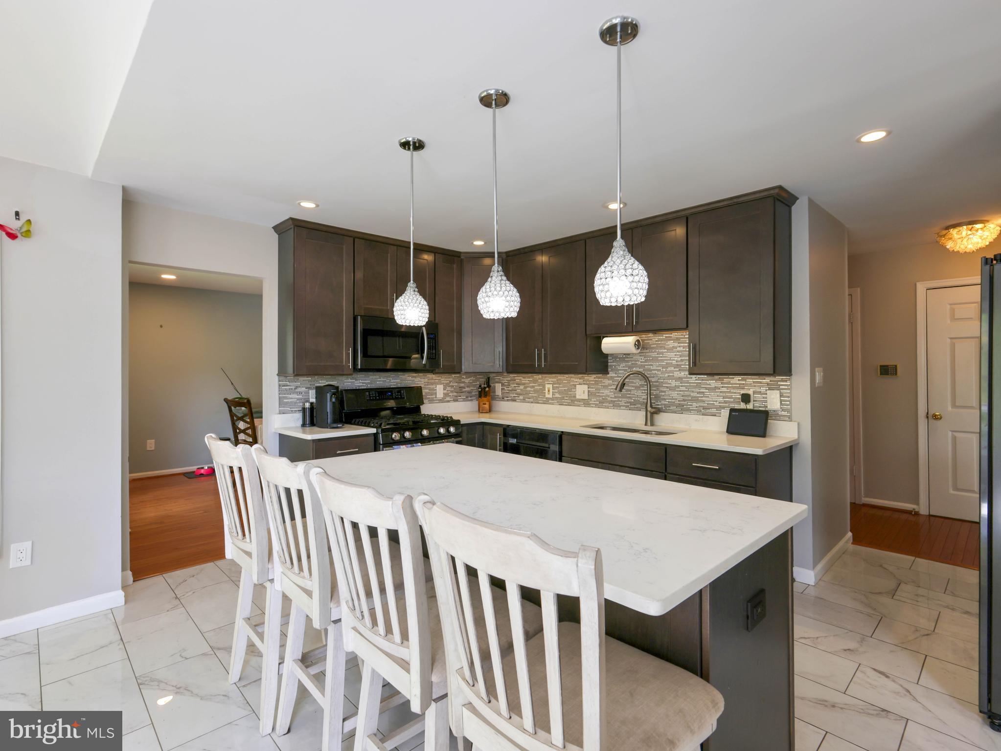 18500 Gingerbread Lane Gaithersburg, MD 20877 - Photo 15 of 56 a large kitchen with kitchen island a island a sink a stove and a refrigerator