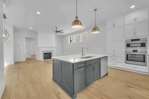 a kitchen with stainless steel appliances granite countertop a sink a microwave oven a refrigerator and a stove