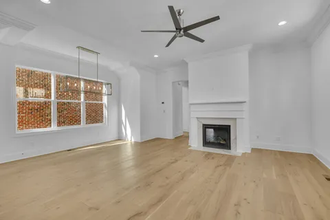 an empty room with windows and fireplace