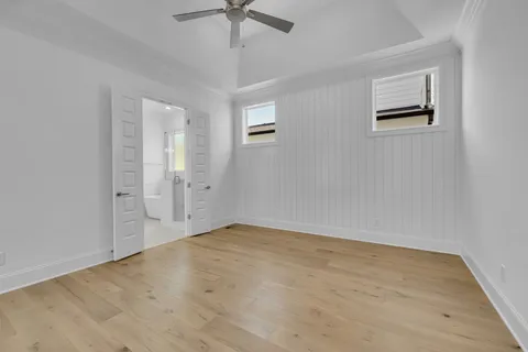 an empty room with windows and fan