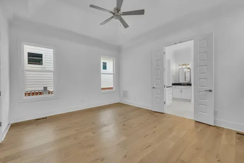 a view of empty room with wooden floor and ceiling fan