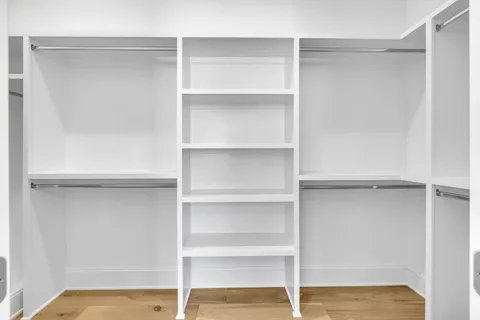 a view of walk in closet with empty racks