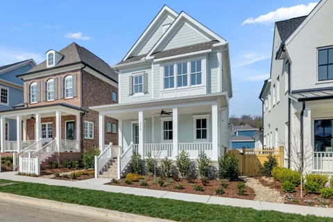 a front view of a house with yard and green space