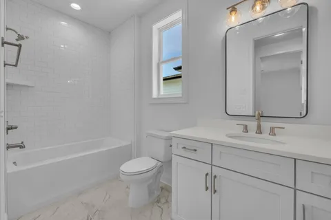 a bathroom with a toilet a sink a mirror and a bathtub