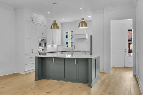 a view of a kitchen with kitchen island a sink stainless steel appliances and cabinets