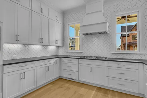 a kitchen with granite countertop white cabinets and sink