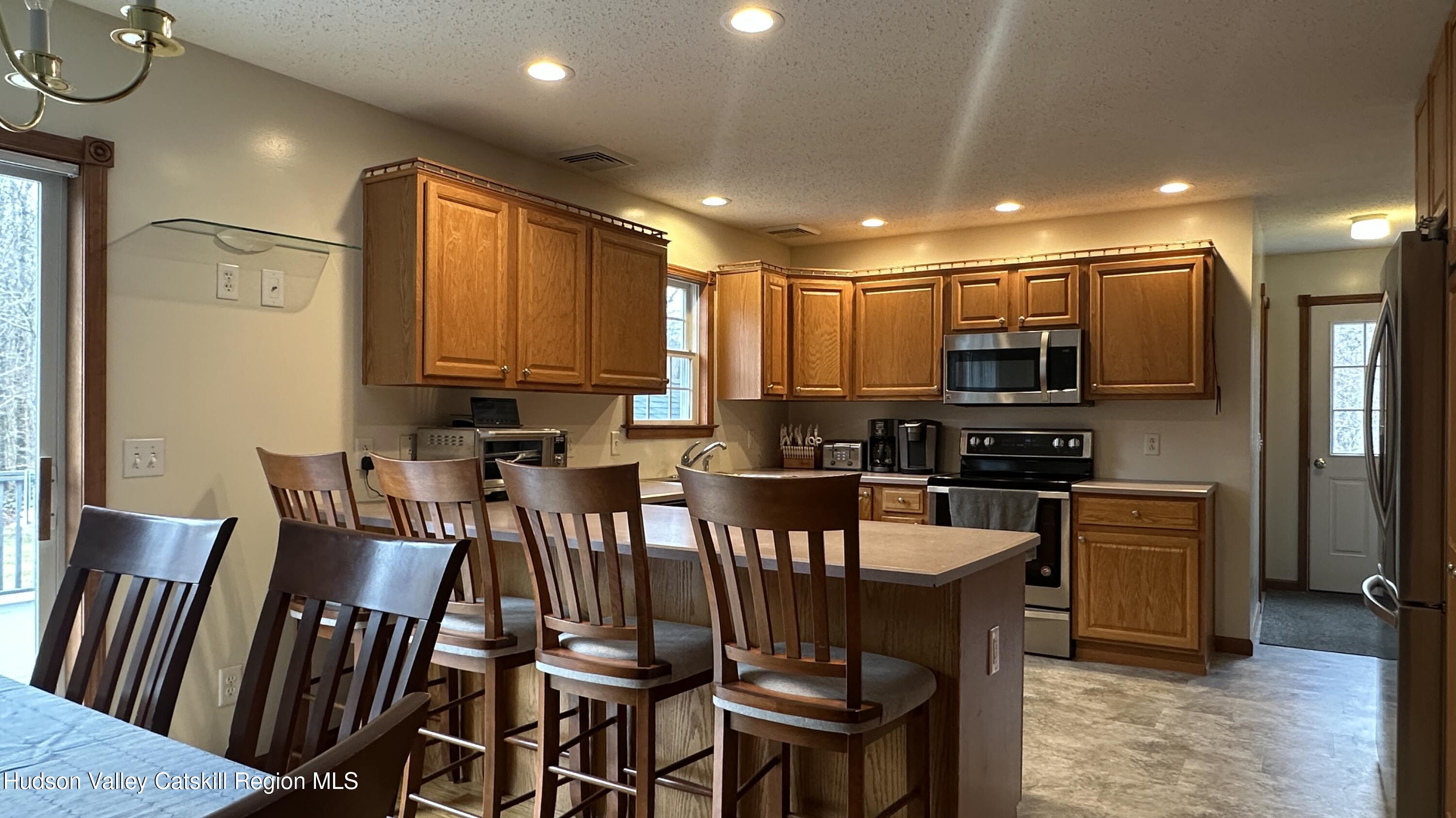 473 North Riverside Road Highland, NY 12528 - Photo 7 of 22 a kitchen with stainless steel appliances kitchen island granite countertop a refrigerator a stove top oven a sink dishwasher and wooden floor