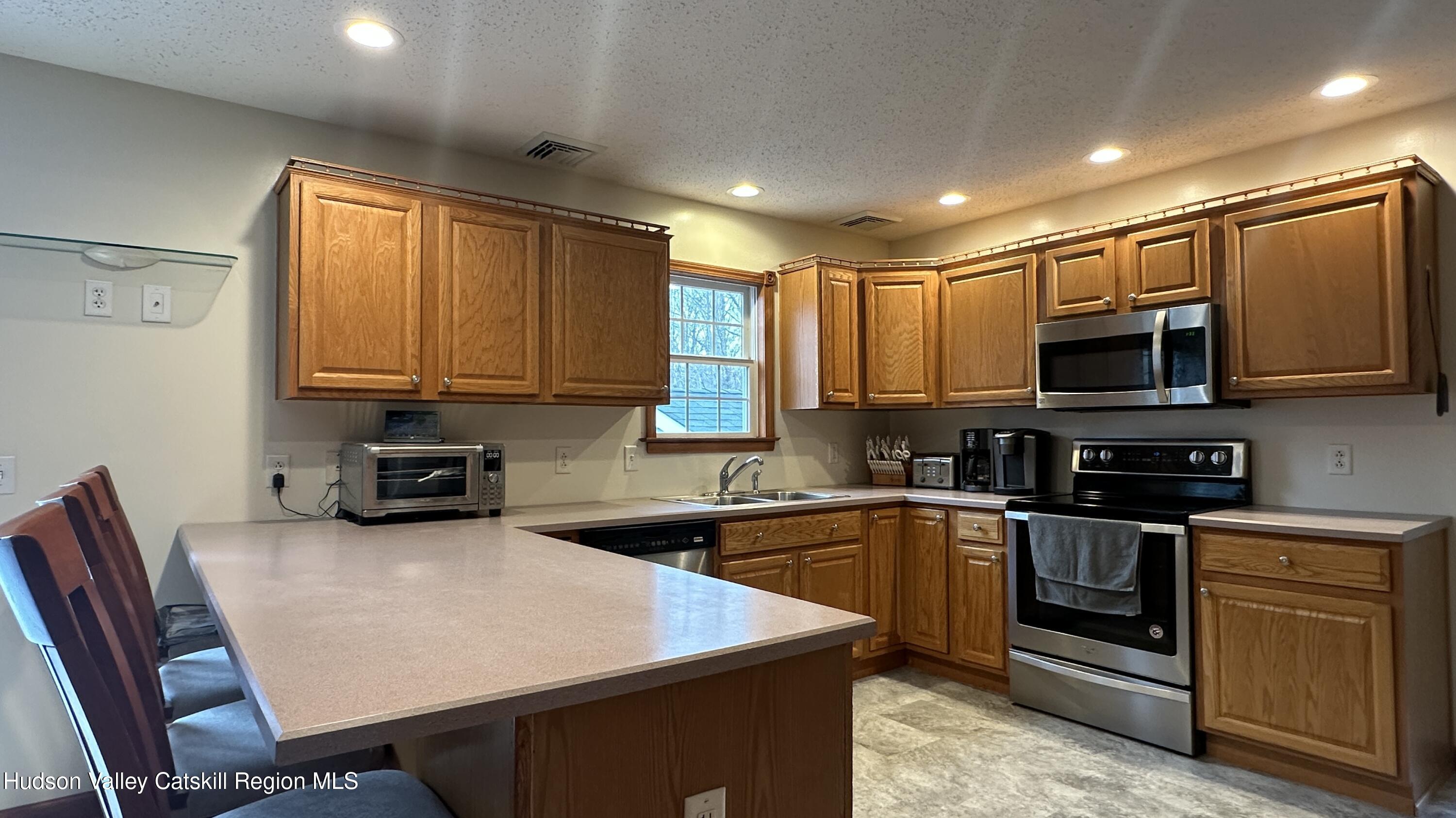 473 North Riverside Road Highland, NY 12528 - Photo 8 of 22 a kitchen with stainless steel appliances granite countertop a sink dishwasher a stove top oven a refrigerator with island and chairs