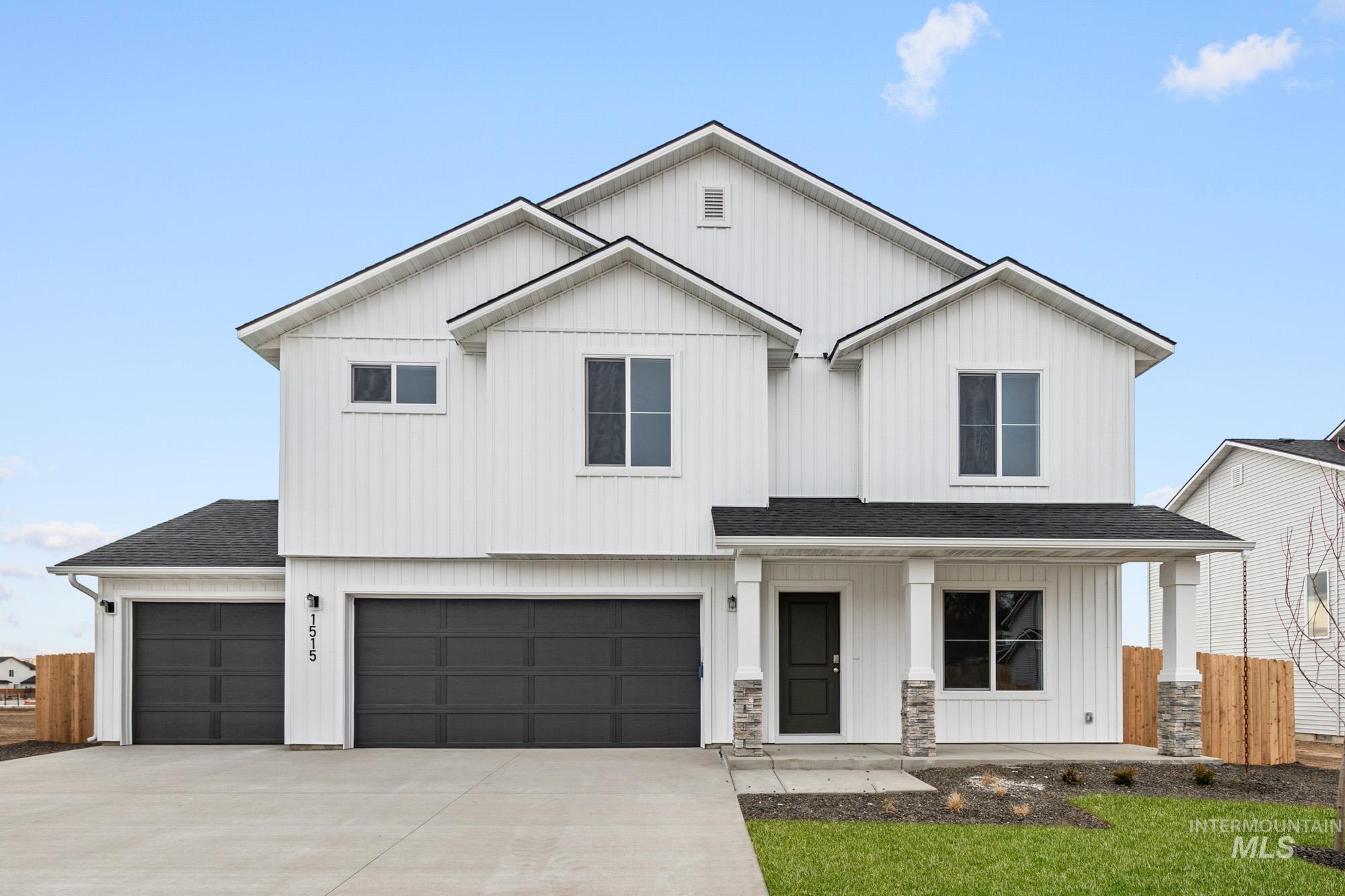 Modern farmhouse with a shingled roof, a porch, board and batten siding, and a garage