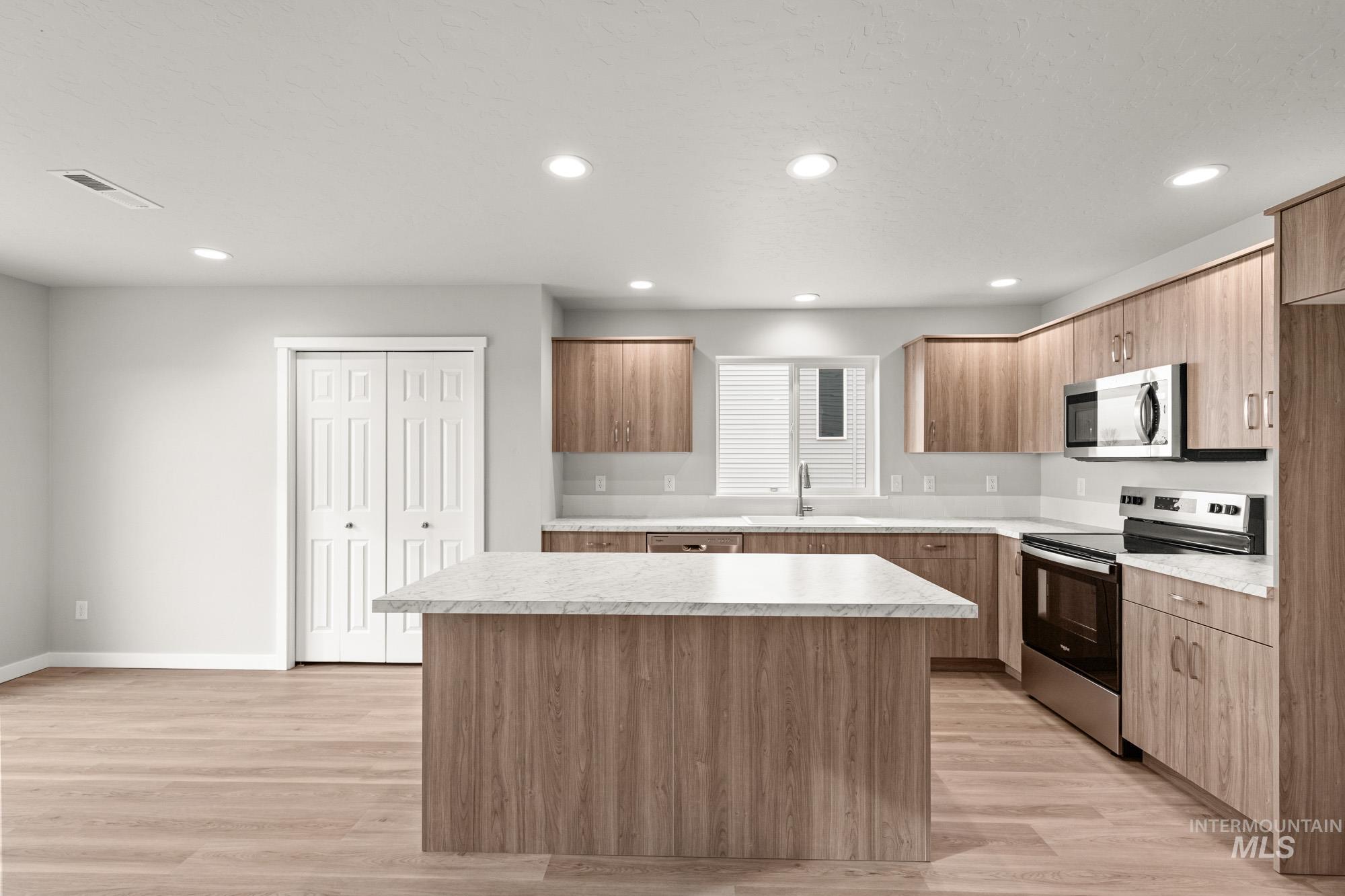 1515 Long Pond Street Middleton, ID 83644 - Photo 4 of 25 Kitchen with stainless steel appliances, light countertops, a center island, light wood-type flooring, and modern cabinets