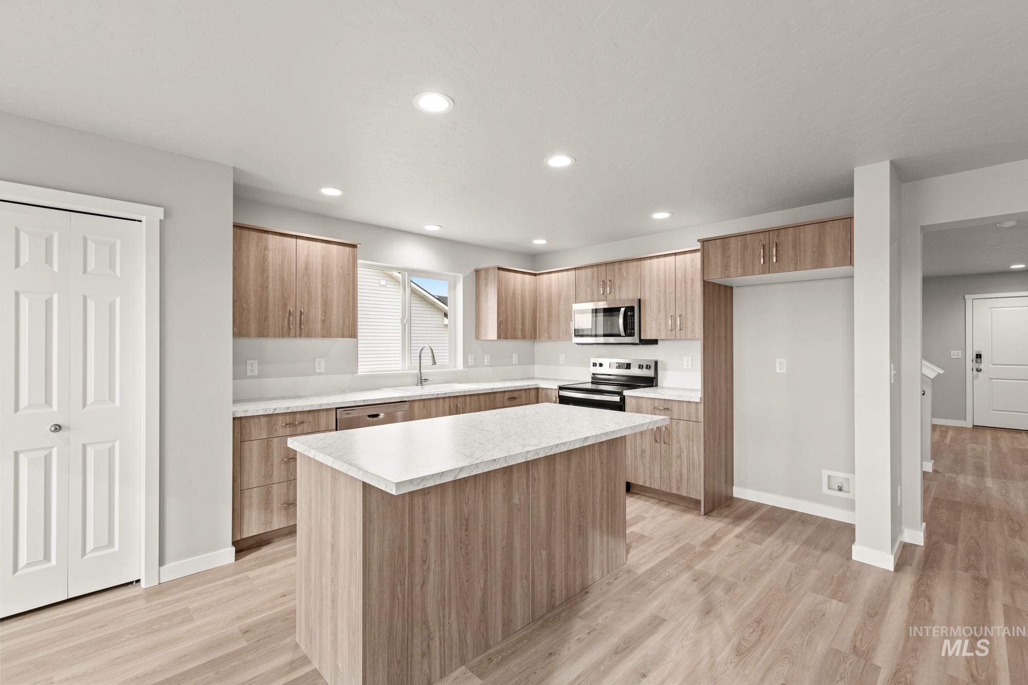 1515 Long Pond Street Middleton, ID 83644 - Photo 5 of 25 Kitchen featuring light countertops, light wood-type flooring, a kitchen island, stainless steel appliances, and recessed lighting