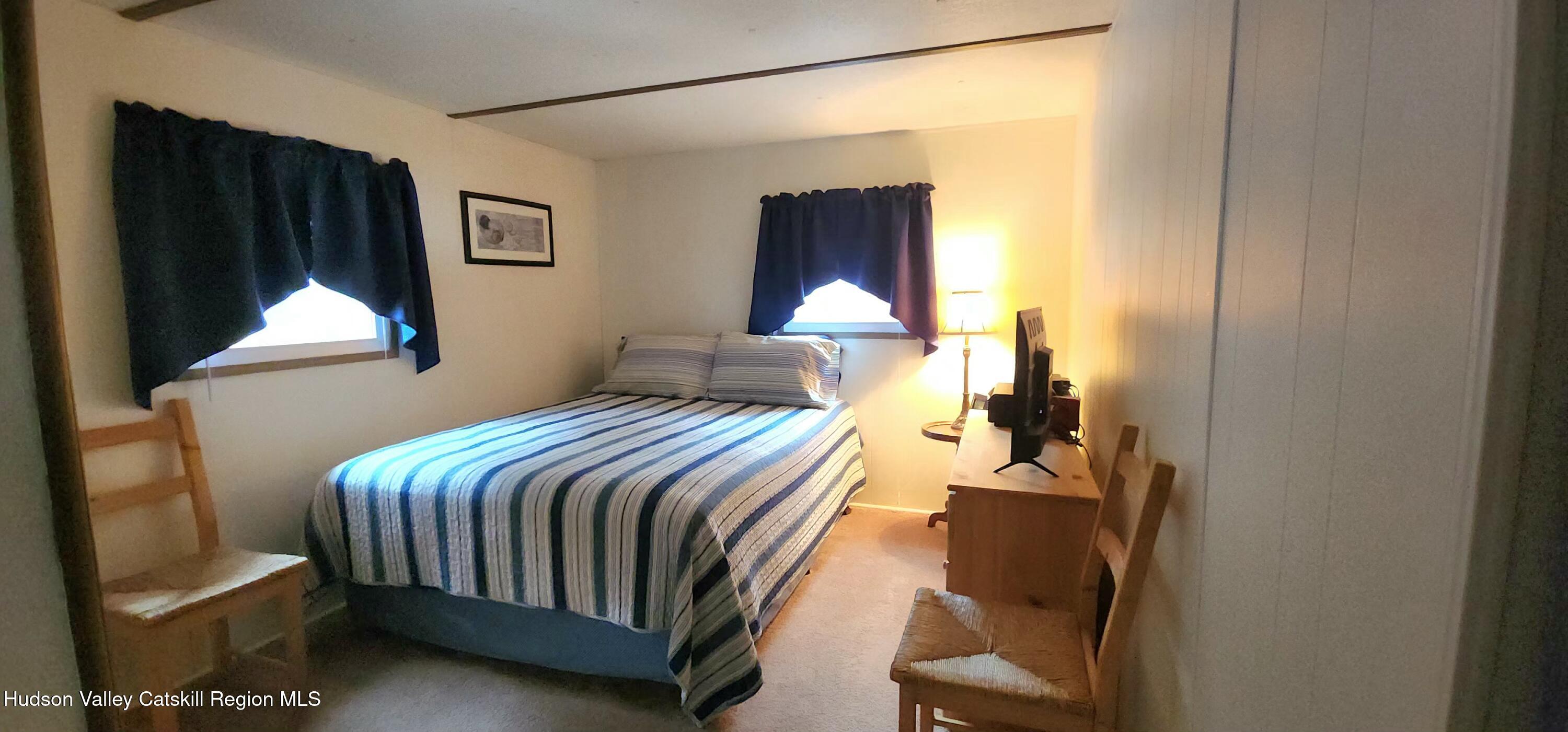 315 Begley Road Windham, NY 12496 - Photo 14 of 22 a bedroom with a bed and a lamp