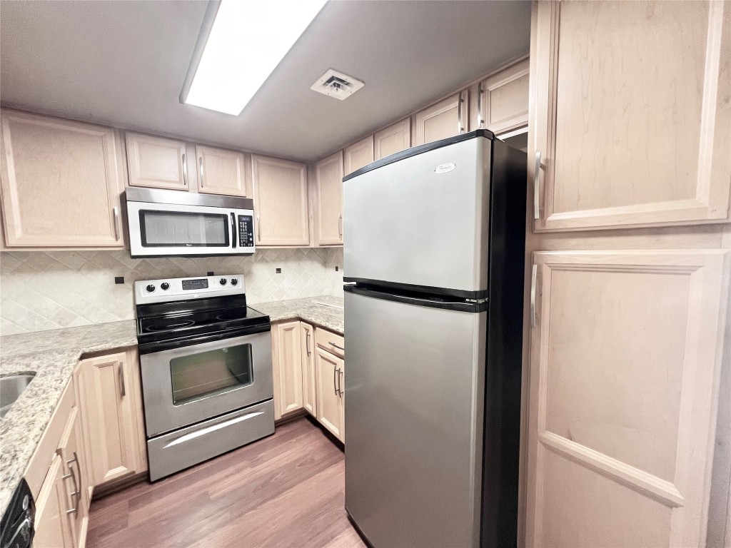 2016 Main Street, Unit 2405 Houston, TX 77002 - Photo 11 of 40 a kitchen with a refrigerator stainless steel appliances and cabinets