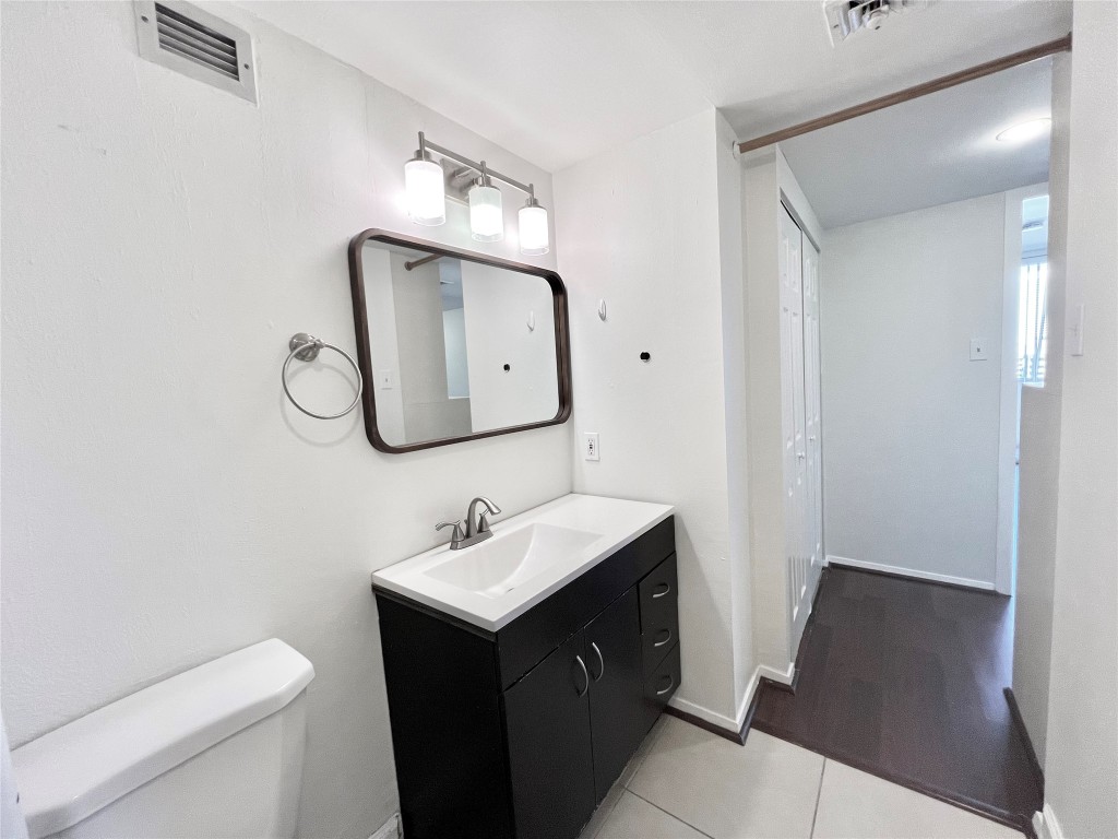 2016 Main Street, Unit 2405 Houston, TX 77002 - Photo 21 of 40 a bathroom with a toilet sink and mirror