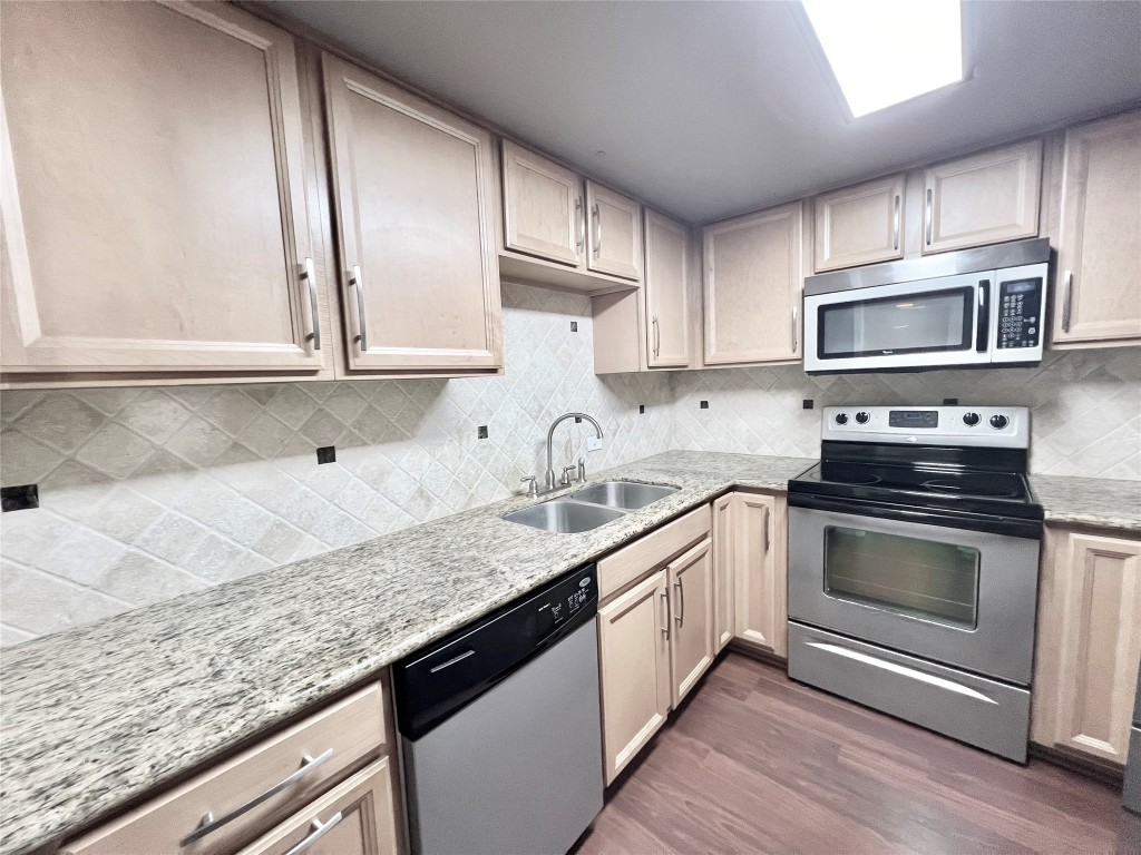 2016 Main Street, Unit 2405 Houston, TX 77002 - Photo 8 of 40 a kitchen with granite countertop a sink stainless steel appliances and cabinets