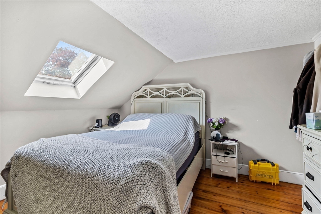 24 River Street, Unit B Danvers, MA 01923 - Photo 13 of 28 a bedroom with a bed and wooden floor