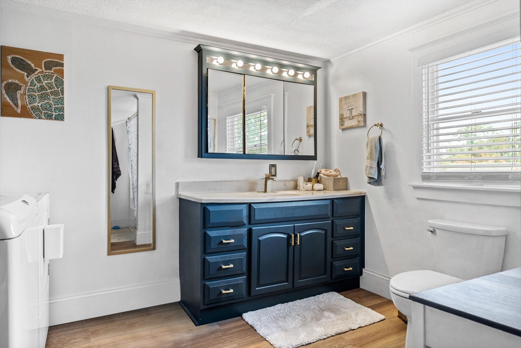 24 River Street, Unit B Danvers, MA 01923 - Photo 19 of 28 a bathroom with a granite countertop sink toilet a mirror and window