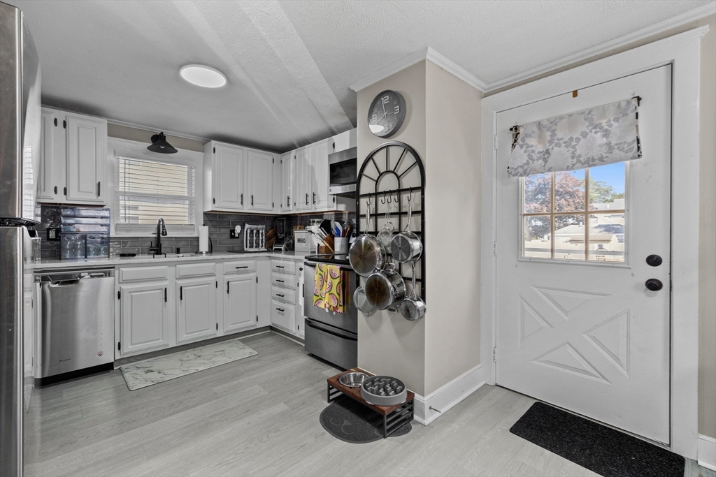24 River Street, Unit B Danvers, MA 01923 - Photo 5 of 28 a kitchen with white cabinets and white appliances