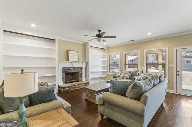 an empty room with wooden floor chandelier fan and windows