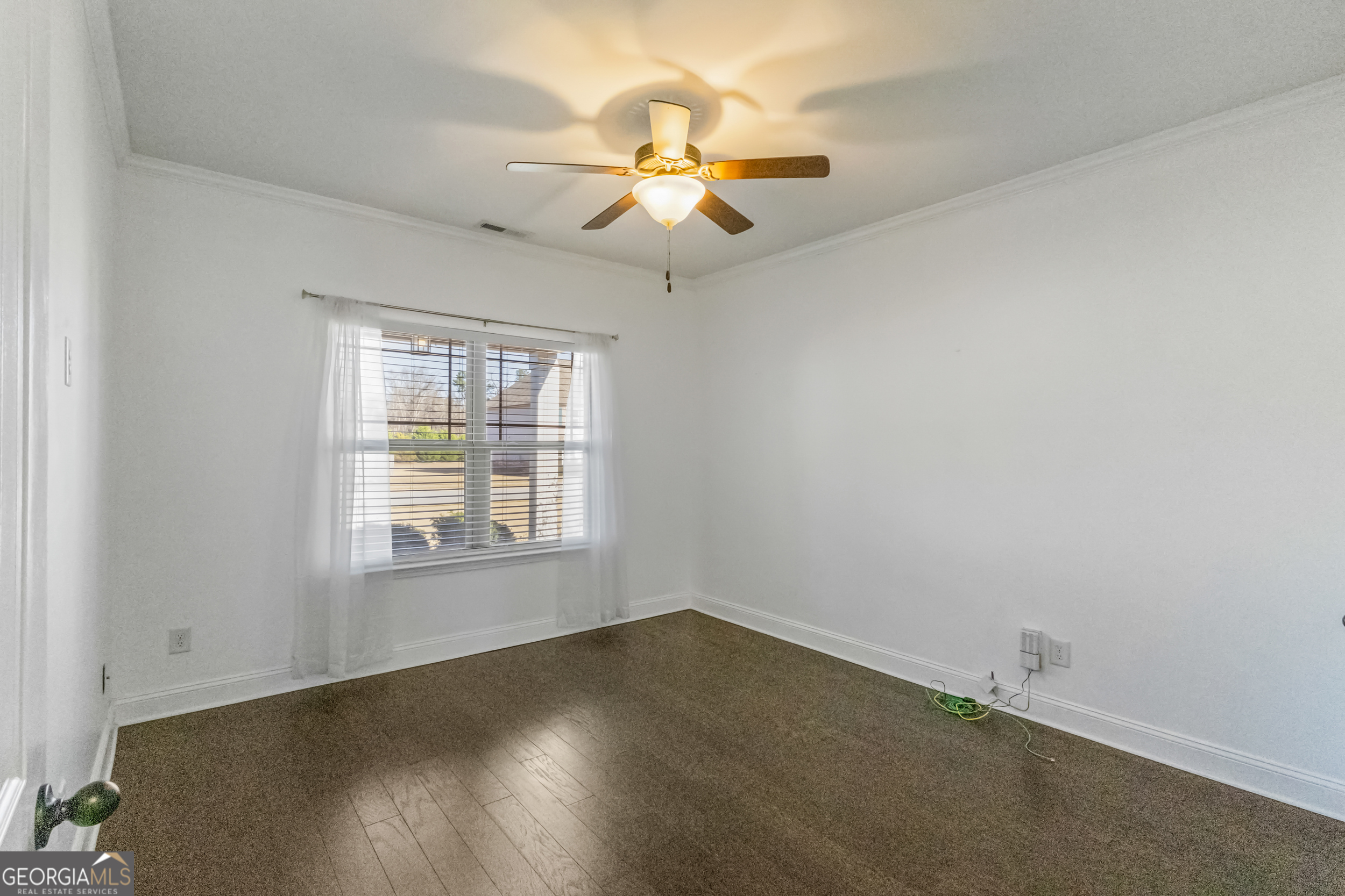 100 Wet Stone Road Senoia, GA 30276 - Photo 37 of 54 an empty room with wooden floor chandelier fan and windows