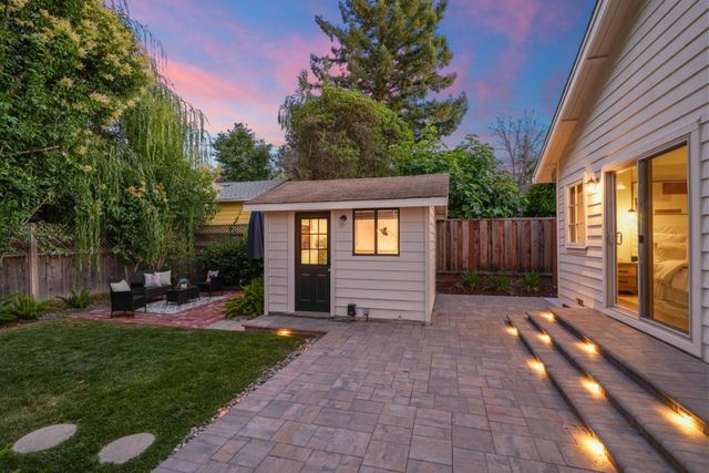 a view of a house with backyard and sitting area