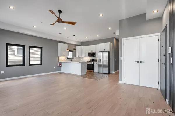 a view of kitchen with stainless steel appliances refrigerator oven and cabinets