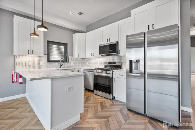 a kitchen with kitchen island granite countertop a sink appliances cabinets and counter space