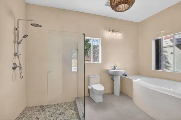a bathroom with a toilet a sink and shower