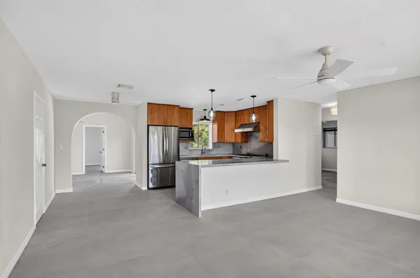 a kitchen with stainless steel appliances kitchen island a refrigerator sink and white cabinets