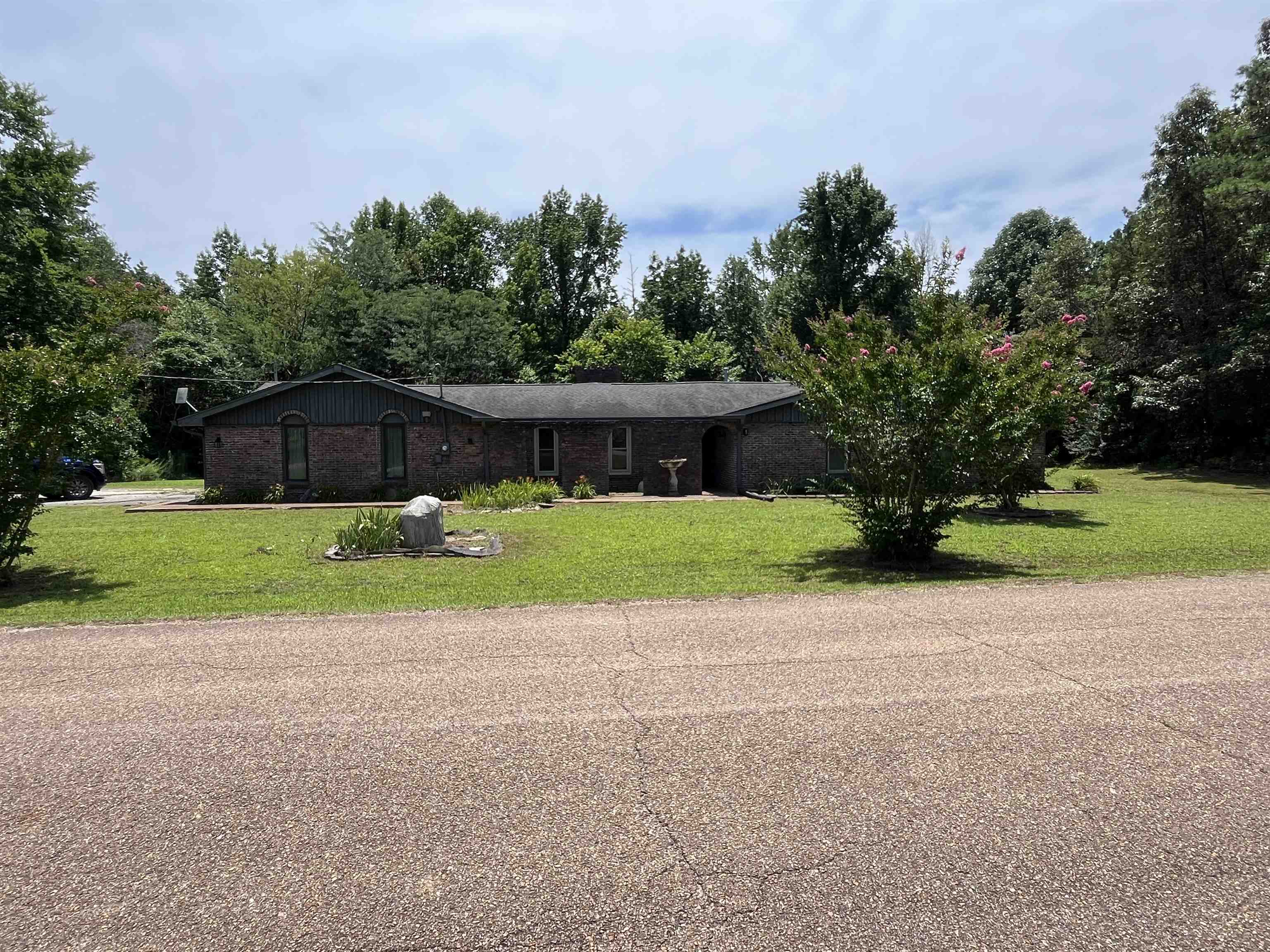 1125 Tyson Road Toone, TN 38381 - Photo 4 of 12 Single-story brick residence featuring a dark roofline and an expansive front lawn