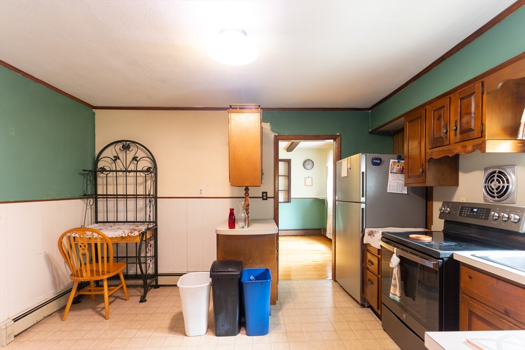 150 Framingham Road, Unit 2 Southborough, MA 01772 - Photo 4 of 20 a kitchen with stainless steel appliances granite countertop a refrigerator a stove and a dining table with wooden floors