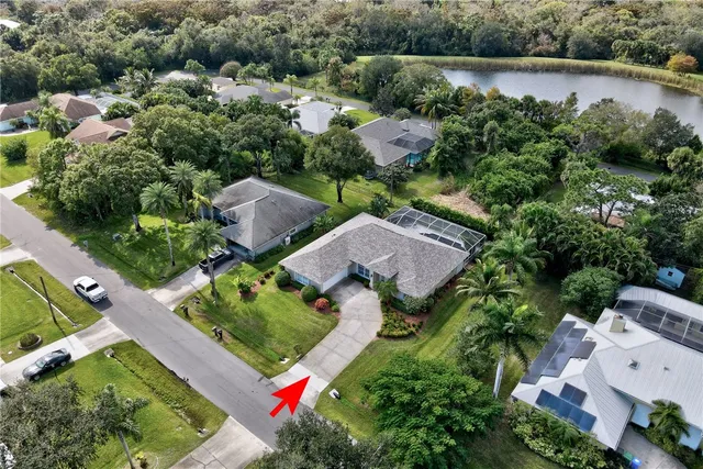 an aerial view of a house with a garden and lake view