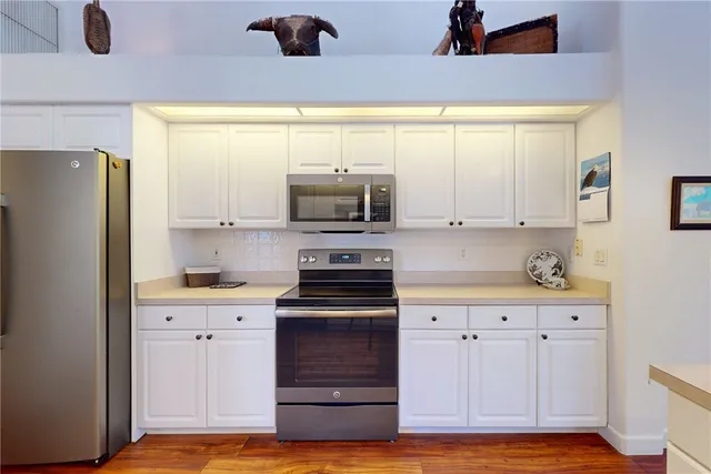 a kitchen with stainless steel appliances white cabinets and a refrigerator