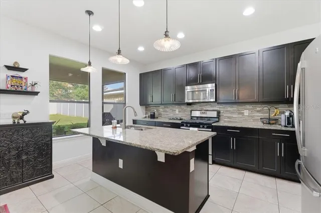 a kitchen with stainless steel appliances granite countertop wooden cabinets a stove a sink and a granite counter tops
