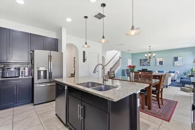 a kitchen with stainless steel appliances a table chairs and refrigerator