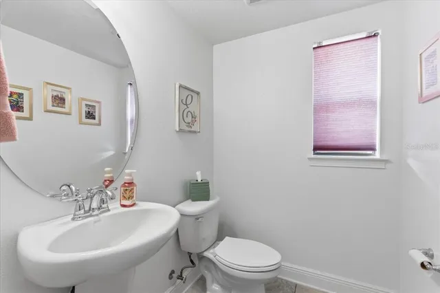 a bathroom with a sink mirror and toilet