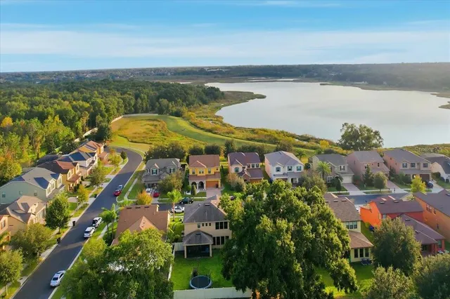 an aerial view of ocean and residential houses with outdoor space