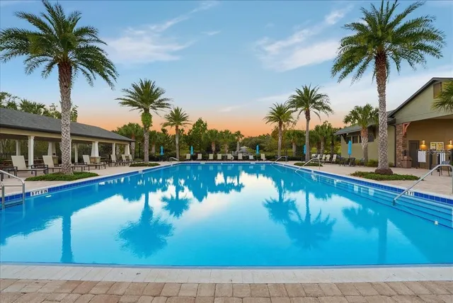 a view of a house with swimming pool and sitting area