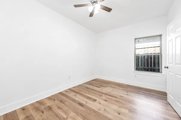 a view of a big room with wooden floor and chandelier fan