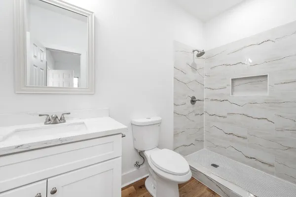 a bathroom with a sink a toilet and shower