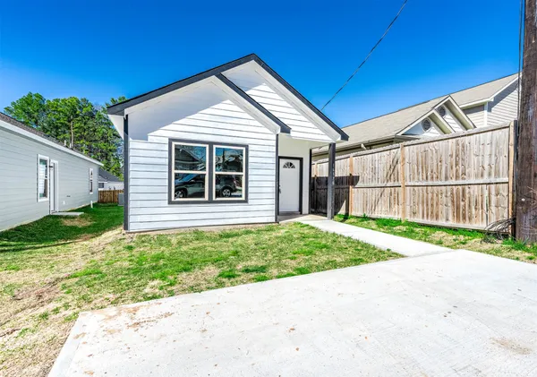 a wooden house with a small yard and wooden fence