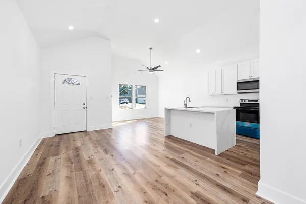 a view of kitchen with sink and refrigerator