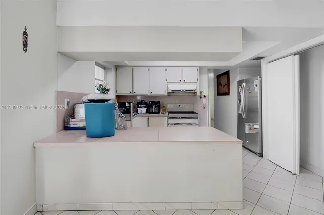 a large white kitchen with cabinets and a refrigerator