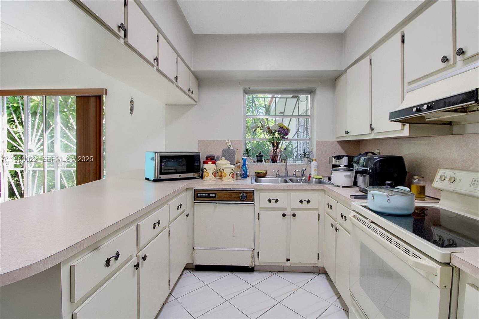 2711 Red Road Coral Gables, FL 33134 - Photo 17 of 33 a kitchen with granite countertop white cabinets white appliances and a window
