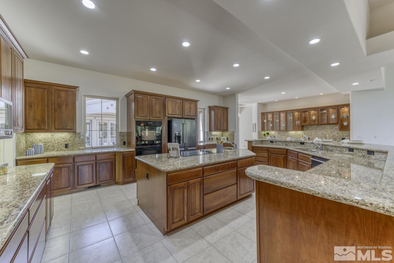 4565 Mountaingate Drive Reno, NV 89519 - Photo 10 of 25 a kitchen with stainless steel appliances granite countertop sink wooden cabinets and granite counter top