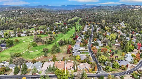 an aerial view of residential houses with outdoor space and trees