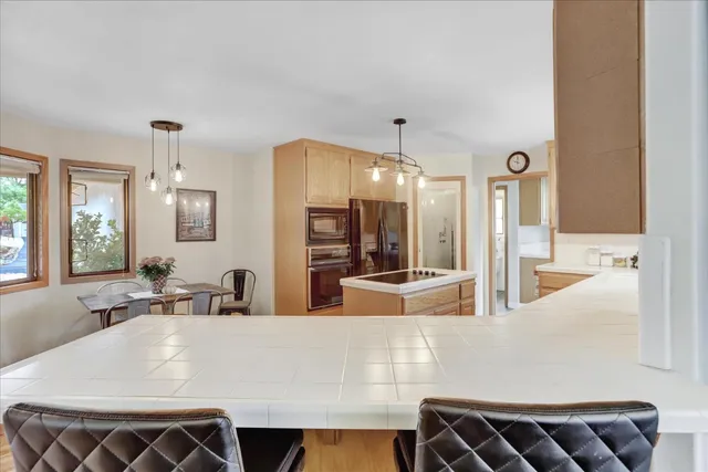 a kitchen with stainless steel appliances granite countertop a sink refrigerator and cabinets