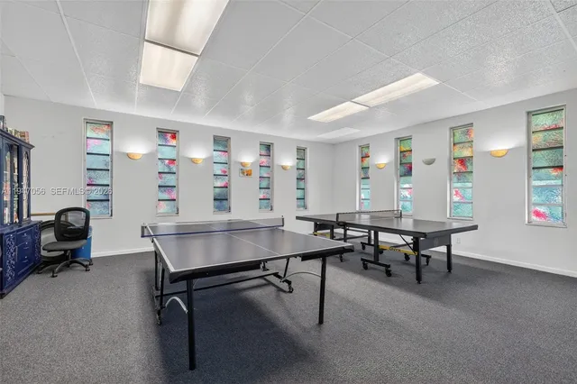 a room with furniture pool table and windows
