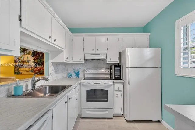 a kitchen with a refrigerator sink and white cabinets