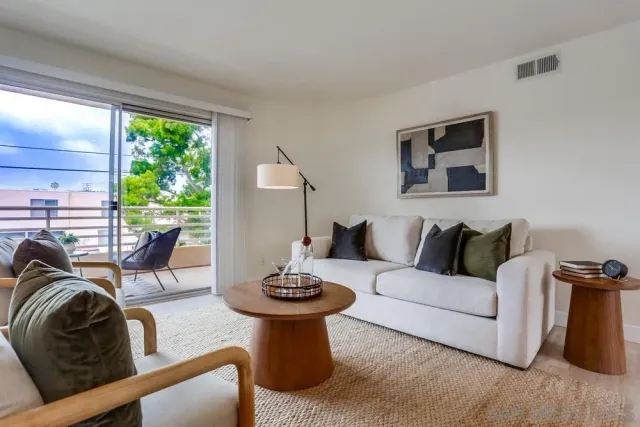 a living room with furniture a window and a potted plant